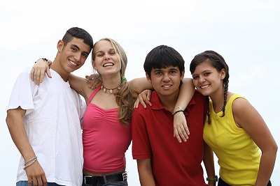 four teenagers smiling and embracing