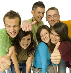 group of young adults smiling with their thumbs up