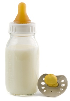 baby bottle with a pacifier next to it