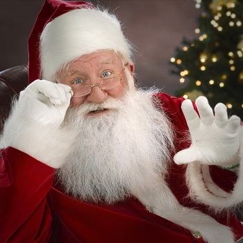 Santa Claus looking over his glasses and waving