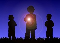 silhouette of children playing in the dark with a flashlight