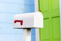 a mailbox in front of a front door where a housewarming party game is being played