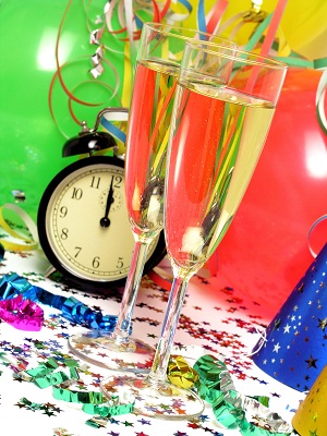 streamers on a table with a clock and two glasses of champagne